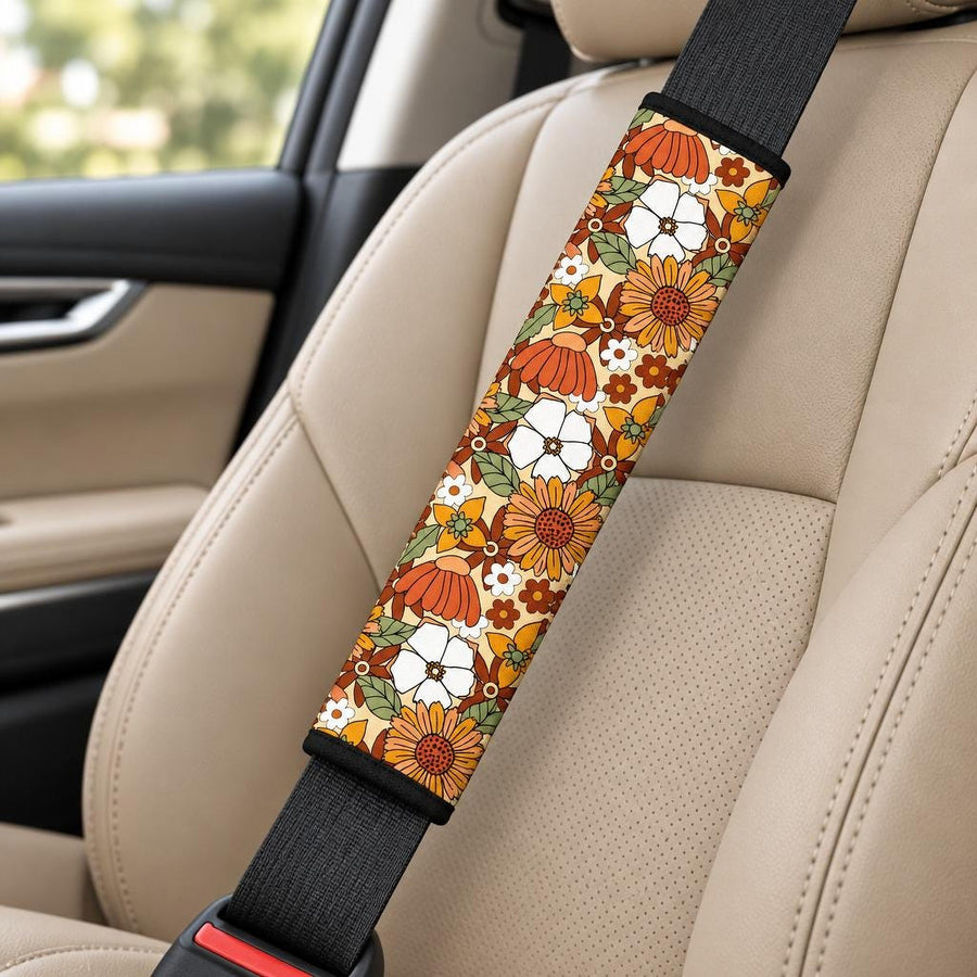 Rustic Blooms Seat Belt Covers (Set of 2) wrapped around a car seat belt across a tan leather front seat