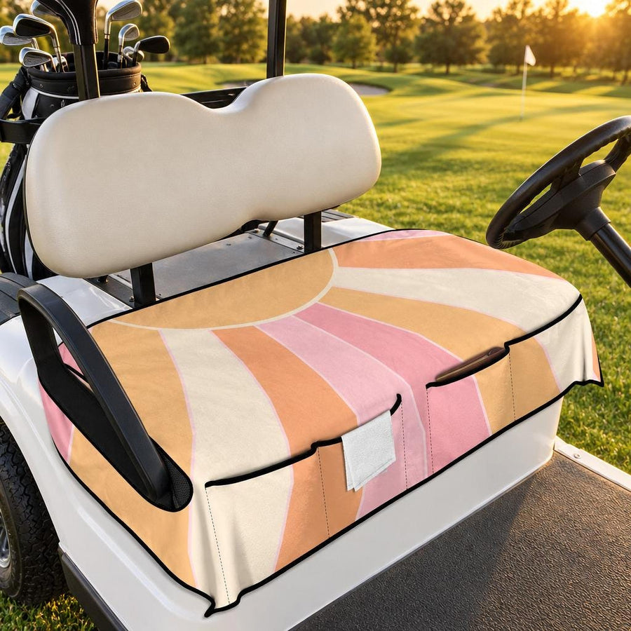 Pastel Retro Sunrise Golf Cart Seat Cover with front pockets, fitted on a white golf cart on a fairway at golden hour