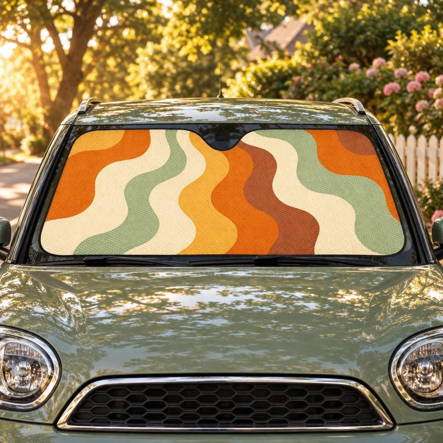 Cascading Retro Vibes Non Outlined Car Shade fitted in the windscreen of a sage-green hatchback on a leafy street at golden hour, printed side facing out