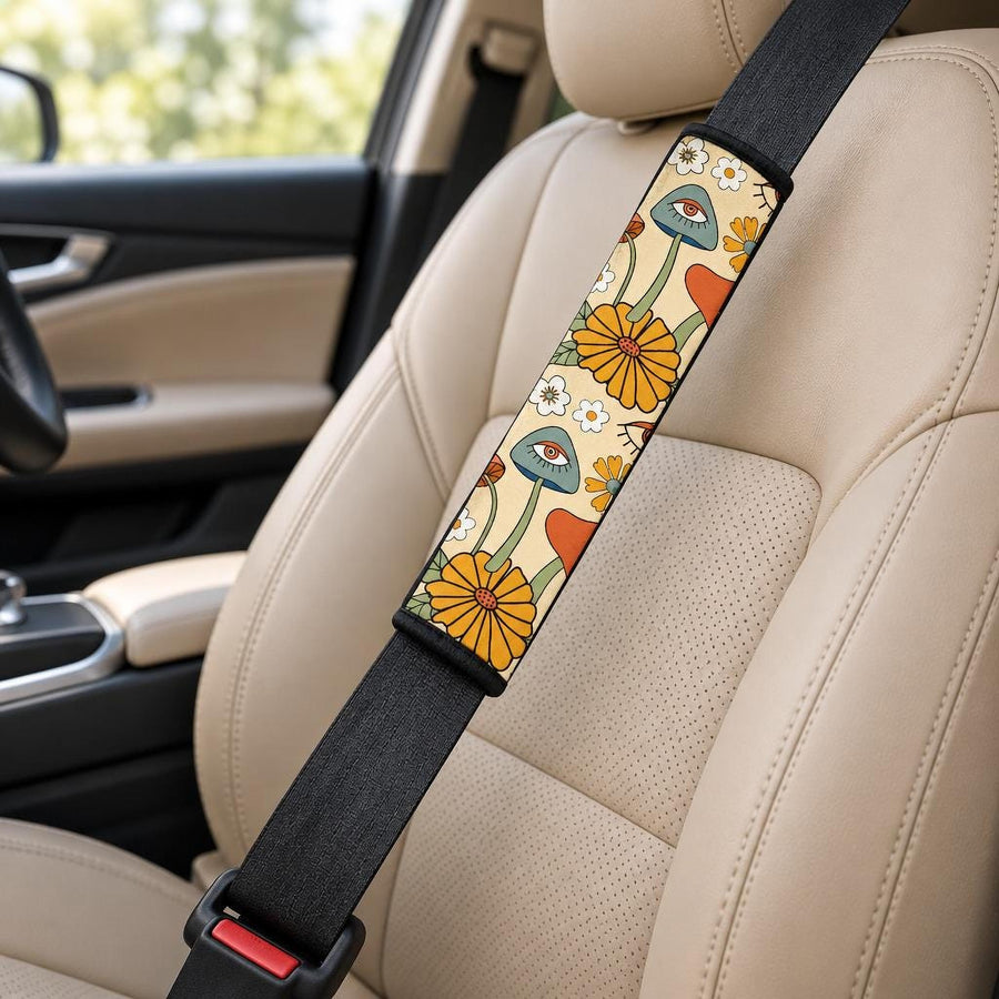 Hippie Mushroom Love Seat Belt Covers (Set of 2) wrapped around a car seat belt across a tan leather front seat