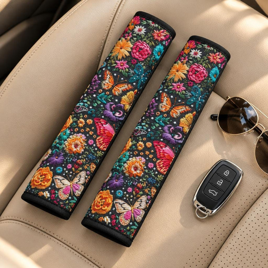 Butterflies Seat Belt Covers (Set of 2) lying side by side on a tan leather car seat with sunglasses and a car key