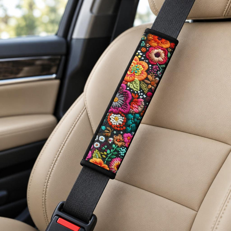 Purple Flowers Seat Belt Covers (Set of 2) wrapped around a car seat belt across a tan leather front seat